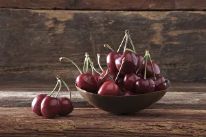 Pastoral Gallery: Bowl of Cherries (Prunus) in front of rustic wood