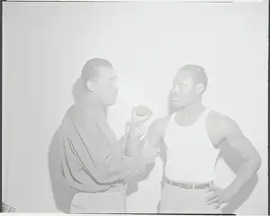 Boxing Champion Joe Louis Examining Muscle of Ezzard Charles