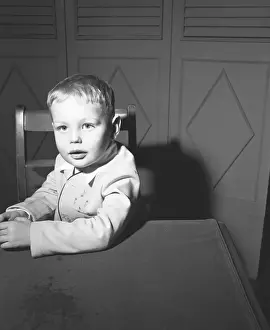 Preschooler Prints: Boy (3-4) sitting at table, (B&W), portrait