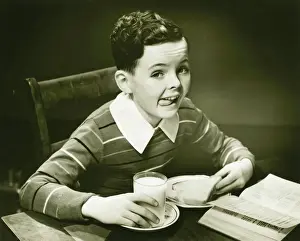 Boy (6-7) eating breakfast, (B&W), portrait