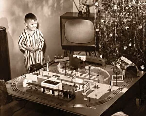 Boy (6-8) looking at model train set on Christmas Day(B&W sepia tone)