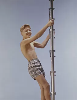 Boy climbing ladder, smiling, portrait