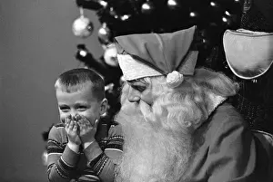 Boy Giggles While Seated on Santa's Lap