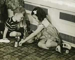 Flooring Prints: Boy and girl (4-5) playing with blocks on floor, (B&W)