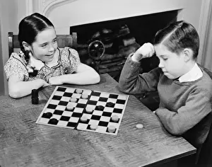 Easy Retouch Prints: Boy and girl (8-9) playing checkers (B&W), elevated view