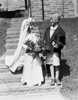 Dedication Gallery: Boy and girl dressed up as bride and groom, outdoors on steps