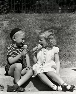 Images Dated 30th June 2008: Boy and girl sitting on curb, eating ice cream cones