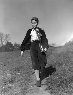 Only Boys Prints: Boy holding books walking along path through meadow, going to school