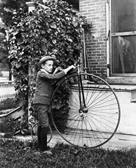 Boy Holding Old Large-Wheel Bicycle