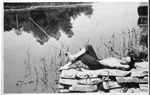 Boy Laying on Rocks While Fishing