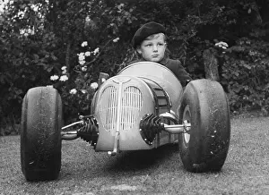 Boy Sitting in His Grand Prix Model Racing Car