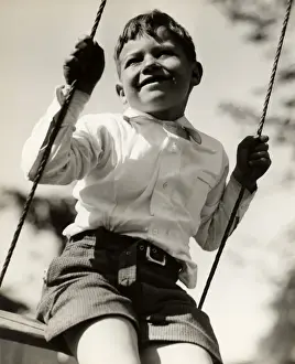 Boy in swing outdoors