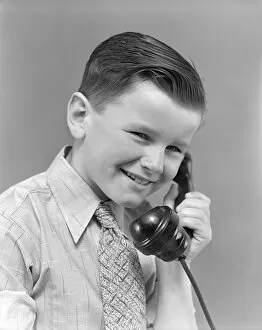 Boy talking on telephone, smiling