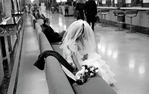 Prints of View of a woman in a wedding dress sitting beside a bouquet of roses on a bench at Grand Central Station on East 42nd Street (between Lexington and Park avenues), New York, New York, December 17 Timeless Moments: A Visual Journey Through History’s Defining Images: Bride In Grand Central Station