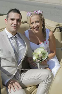 Images Dated 9th August 2014: Bride and groom posing in the back seat of an open car, convertible