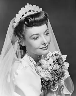 Bride holding bouquet, posing in studio (B&W), , portrait