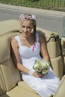 Images Dated 9th August 2014: Bride posing in the back seat of an open car, convertible