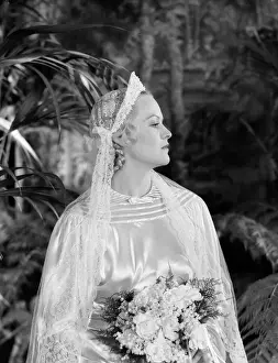 One Mid Adult Woman Only Prints: Bride wearing tiara, veil and silk wedding dress, holding bridal bouquet