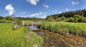 Bridge over the Morsbach stream with green meadows, Altmuhltal Nature Park, Bavaria, Germany