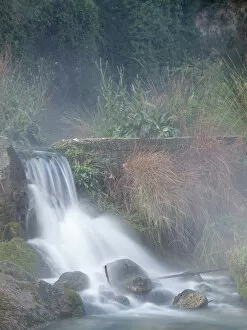 Broken dam in a river with a waterfall and steam
