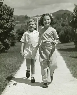 Brother Prints: Brother and sister (4-5) walking on path, (B&W)