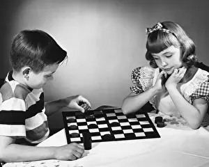 Checkers Prints: Brother and sister playing checkers at table