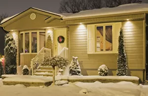 Images Dated 28th December 2011: Bungalow style residential home illuminated in winter at dusk with Christmas decorations, Quebec