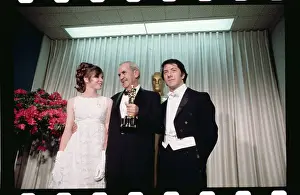 Burnett Guffey Holding His Trophy While Posing With Movie Stars