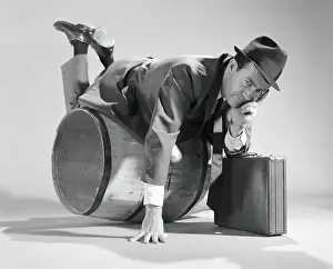 Only Mature Men Prints: Businessman over a barrel, holding briefcase