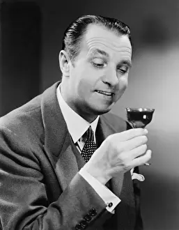 50 59 Years Prints: Businessman with glass of beverage, posing in studio, (B&W), close-up