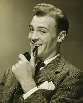 30 35 Years Prints: Businessman holding pipe in mouth, smiling, (B&W), portrait