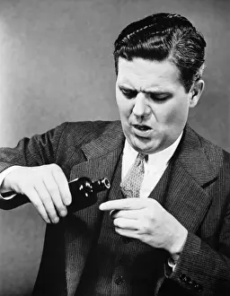 Anguished Prints: Businessman pouring medicine, , (B&W)