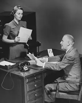 Easy Retouch Prints: Businessman sitting at desk talking to secretary (B&W)