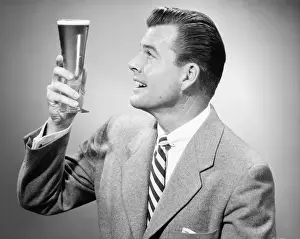 30 35 Years Prints: Businessman in full suit in studio holding glass of beer, (B&W)
