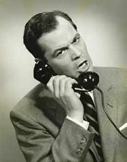 Using Phone Prints: Businessman using phone in studio, (B&W), close-up