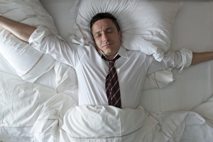 Business Travel Collection: Businessman waking up with clothes on