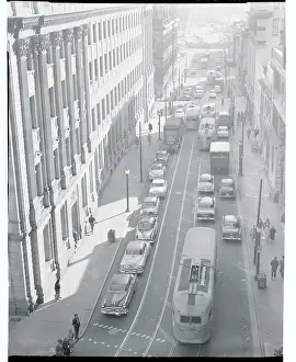 Busses and Cars Driving Down a City Street