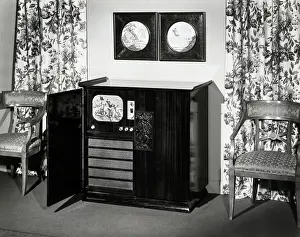 Prints of (Original Caption). View of a Stromberg Carlson Chinese Modern cabinet console television with door open to reveal an image of a football game on the screen. Photograph, 1948 Gridiron Glory: Cabinet Console Tv Showing Football Game
