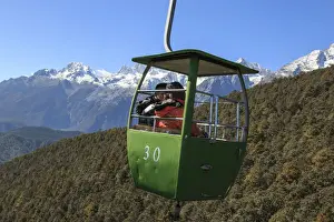 Natural Reserve Prints: Cable Car on foreground with some tourists inside and Jade Dragon Snow Mountain on foreground