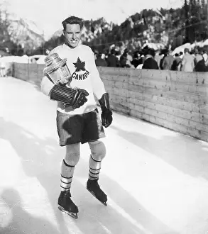 Prints of (Original Caption) 1928-St. Moritz, Switzerland- Photo shows Captain Porter of the Canadian Hockey Team, which won the Olympic title at the winter sports carnival. The U.S. won second place Frozen Moments: A Journey Through Hockey History: Canadian Hockey Captain with Olympic Trophy
