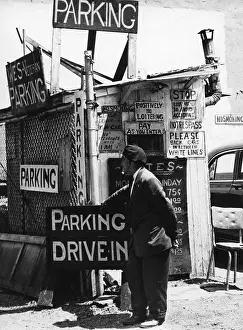 Prints of BROOKLYN, NY - MARCH 1958: A car park attendant stands by his hut among many signs in Brooklyn Heights in March 1958 in New York City, New York. (Photo by David Attie/Getty Images) Portraits, Artworks, and Montages from a Visionary Photographer: Car Park