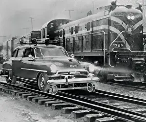 Car Riding the Rails Next to a Train