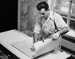 Carpenter putting on wallpaper
