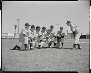 Casey Stengel Bending to Talk to Players Crouched on Field