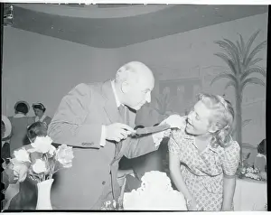 Cecil B. Demille Feeding Cake to Madeleine Carroll