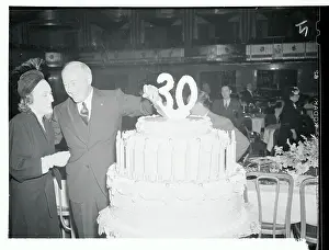 Cecil B. DeMille and Gloria Swanson Standing Next to Large Cake