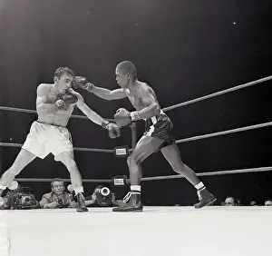 Challenger Johnny Saxton Attacks defending welterweight champion Carmen Basilio, left, during 9th round their title bout at Chicago Stadium 3/14. Saxton took a 15 round decision and the crown from Basilio