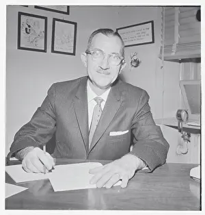 Charles Schneider Seated at Desk