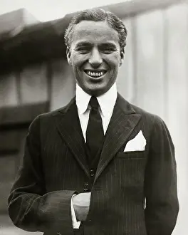 Prints of Up close shot of Charles Chaplin (1889-1977), without mustache. He is smiling with his hand in his jacket Master of Mime, Icon of Cinema: Chaplin in Prints: Charlie Chaplin