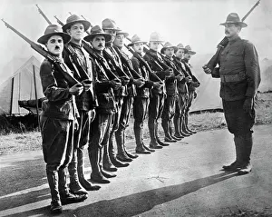 Prints of (Original Caption). Charles Chaplin in Shoulder Arms. Recruits in line At The Movies: Charlie Chaplin Standing at Shoulder Arms